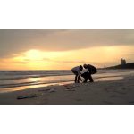 ویدیو استوک خانواده آسیایی در حال تمیز کردن ساحل غروب